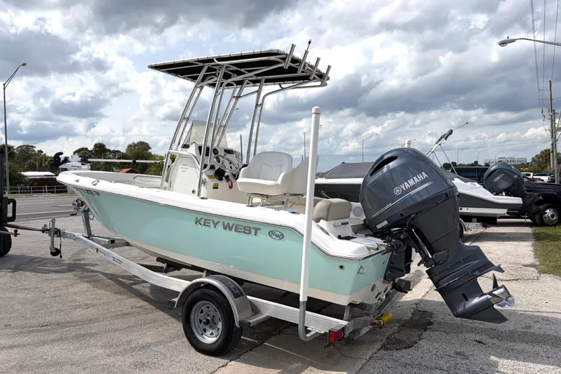 Slide: The Image of 2023 Key West 189 FS boat with Yamaha engine on trailer, parked outdoors. - 2