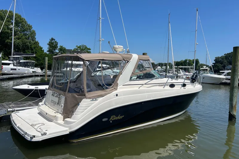 The Image of 2006 Rinker Fiesta Vee 342 boat docked in a marina under clear blue skies. - 1
