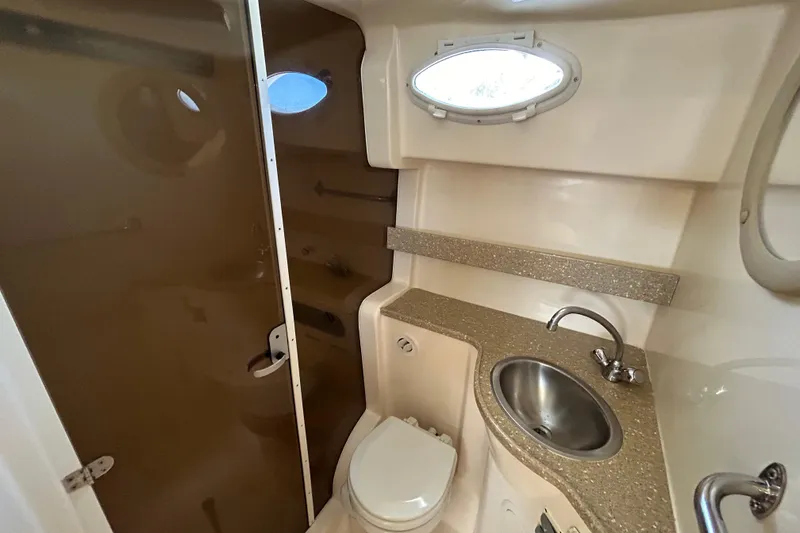 Slide: The Image of 2006 Rinker Fiesta Vee 342 bathroom with sink, toilet, and porthole window. - 11