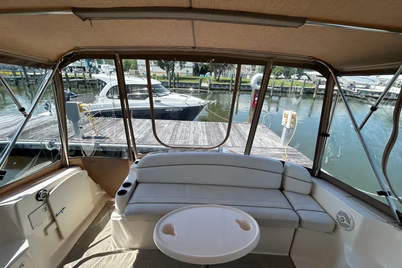 Slide: The Image of 2006 Rinker Fiesta Vee 342 interior with dock view, featuring seating and table. - 4