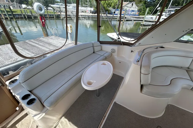 Slide: The Image of 2006 Rinker Fiesta Vee 342 boat interior with seating and table, docked at marina. - 6