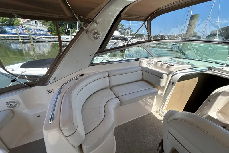 Slide: The Image of 2006 Rinker Fiesta Vee 342 boat interior with beige seating and marina view. - 7