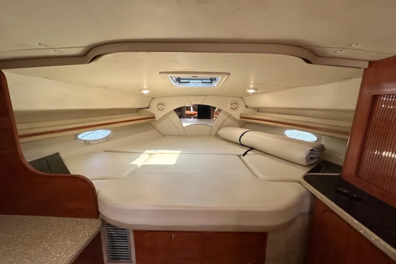 Slide: The Image of 2006 Rinker Fiesta Vee 342 cabin interior with cozy sleeping area and portholes. - 8