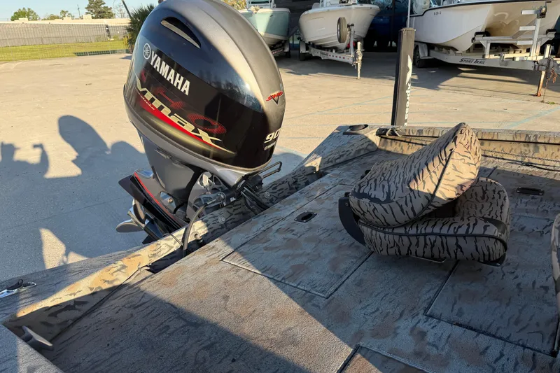 Slide: The Image of 2019 Xpress XP7 boat with Yamaha Vmax engine, camo seats, and parked boats in background. - 11