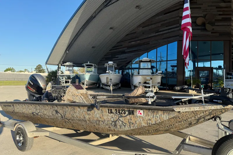 Slide: The Image of 2019 Xpress XP7 boat with camouflage design on a trailer outside a showroom. - 6