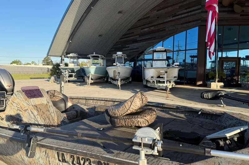 Slide: The Image of 2019 Xpress XP7 boat displayed outside showroom with other boats and American flag. - 7