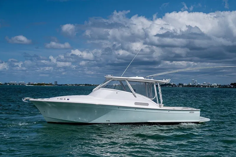 The Image of 2012 Brooks Boatworks 34 cruising on a sunny day with a city skyline in the background. - 0