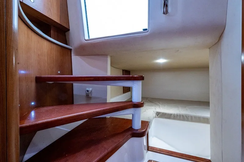 Slide: The Image of Interior of 2012 Brooks Boatworks 34, featuring wooden stairs and cozy sleeping area. - 16