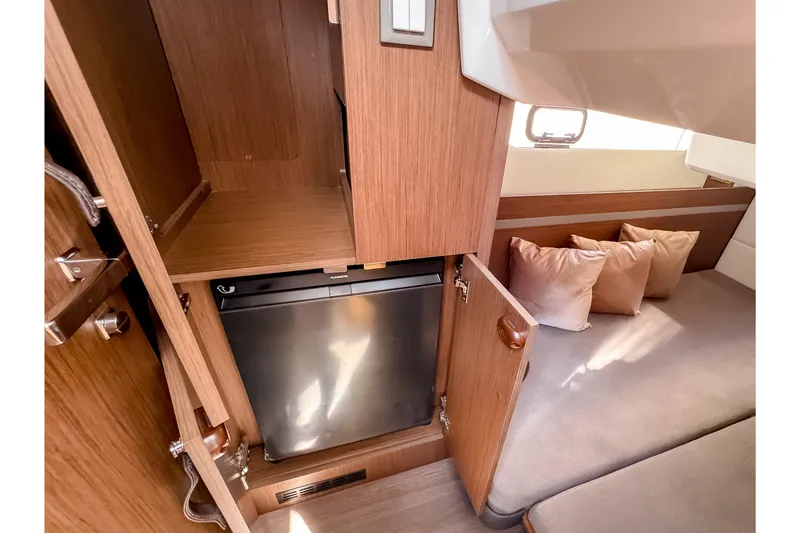 Slide: The Image of Interior of 2026 Beneteau Antares 12 Coupe with fridge and seating area. - 27