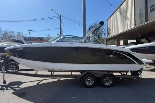 Slide: The Image of 2015 Cobalt R5 boat on trailer, parked outdoors near a building. - 6