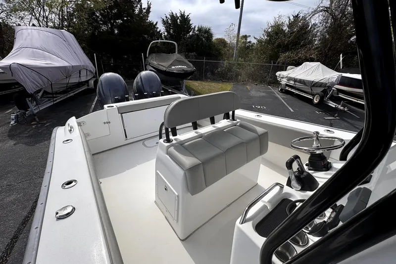 Slide: The Image of 2020 Cape Horn 27 XS boat interior with dual engines and covered boats in background. - 11
