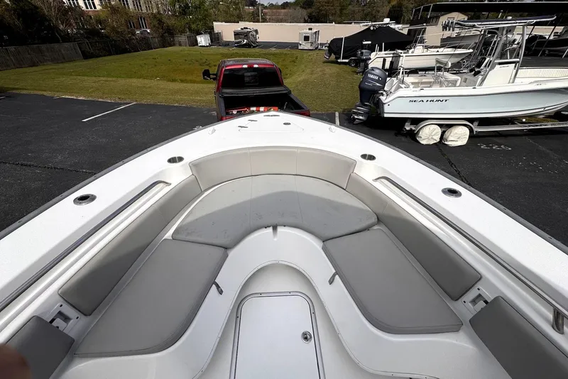 Slide: The Image of 2020 Cape Horn 27 XS boat interior with cushioned seating and a view of a parked truck. - 15