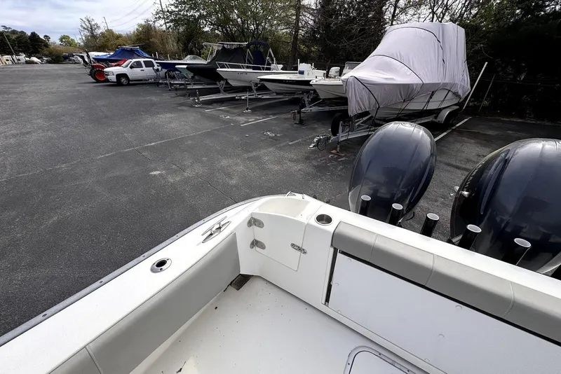 Slide: The Image of 2020 Cape Horn 27 XS boat in storage lot with covered vessels and parked vehicles. - 21