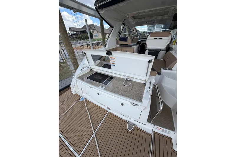 Slide: The Image of 2017 Sea Ray Sundancer 350 Coupe interior with open storage compartment and seating area. - 2