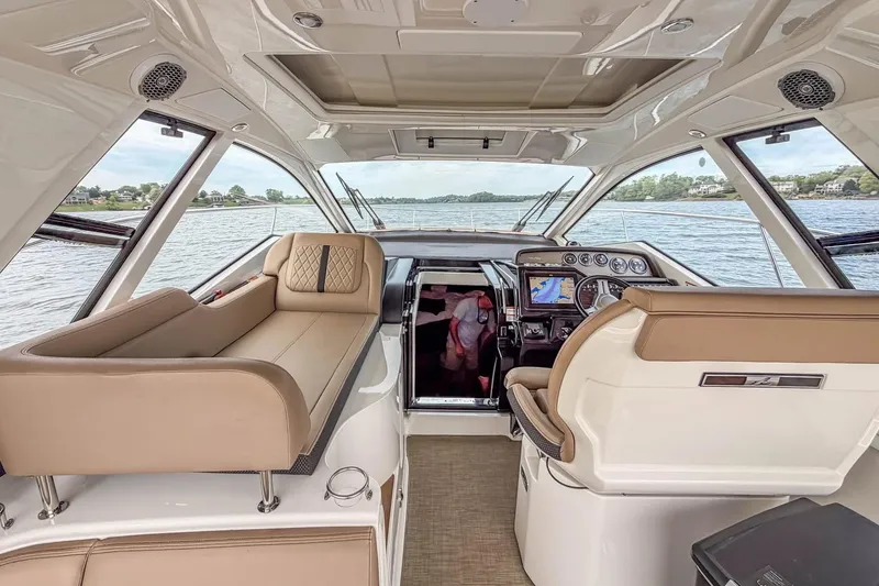 Slide: The Image of Interior of 2017 Sea Ray Sundancer 350 Coupe, featuring luxurious seating and navigation controls. - 23