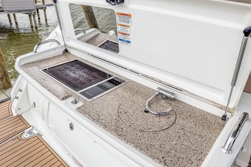 Slide: The Image of Outdoor kitchenette on 2017 Sea Ray Sundancer 350 Coupe with grill and sink. - 26