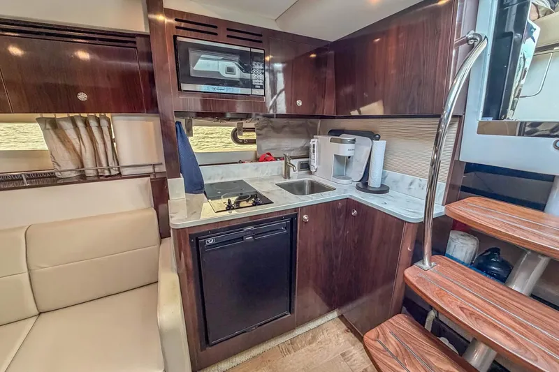 Slide: The Image of Luxurious 2017 Sea Ray Sundancer 350 Coupe interior with modern kitchenette and wooden accents. - 29