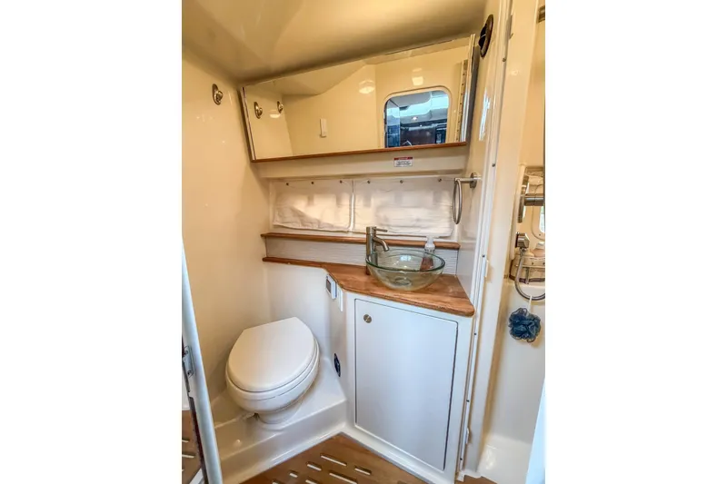 Slide: The Image of 2017 Sea Ray Sundancer 350 Coupe bathroom with glass sink and wooden countertop. - 34