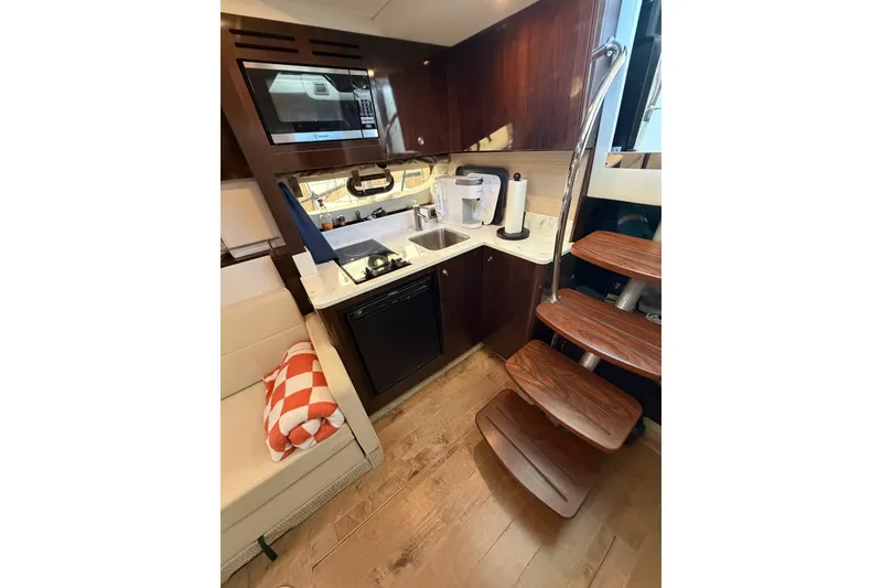 Slide: The Image of Interior of 2017 Sea Ray Sundancer 350 Coupe with kitchenette and wooden stairs. - 6