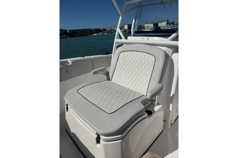 Slide: The Image of 2021 Sea Fox 288 Commander boat seat with cushioned design, set against a marina backdrop. - 23