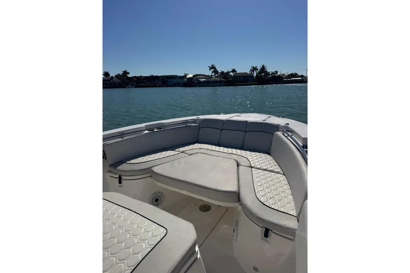 Slide: The Image of 2021 Sea Fox 288 Commander boat interior with cushioned seating, on calm water. - 24