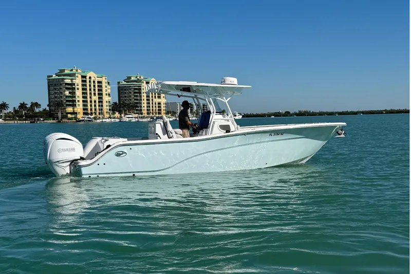 Slide: The Image of 2021 Sea Fox 288 Commander boat on calm water with buildings in the background. - 27