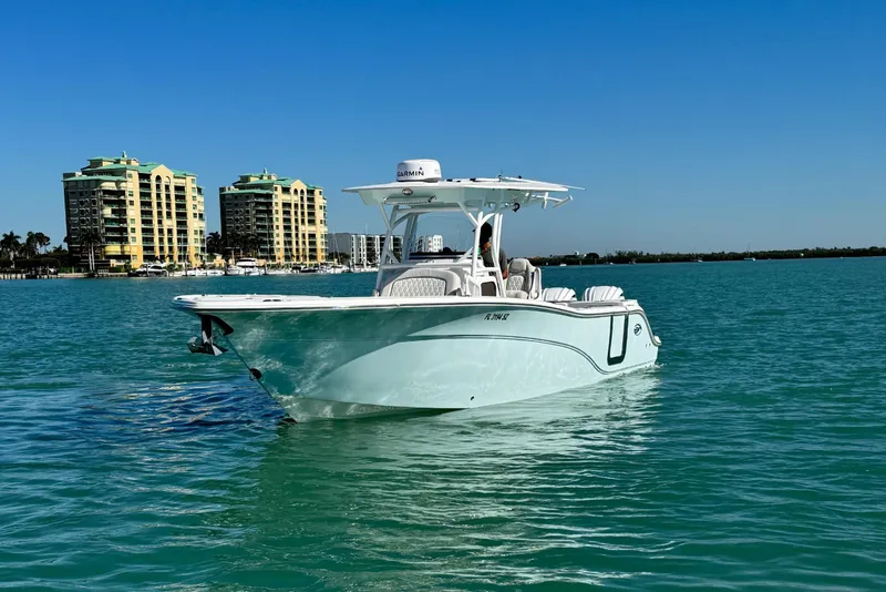 Slide: The Image of 2021 Sea Fox 288 Commander boat on turquoise water with buildings in the background. - 30