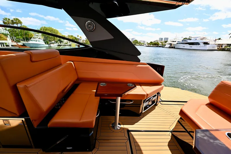 Slide: The Image of Luxurious 2022 Cruisers Yachts 38 GLS OB interior with orange seating and waterfront view. - 10