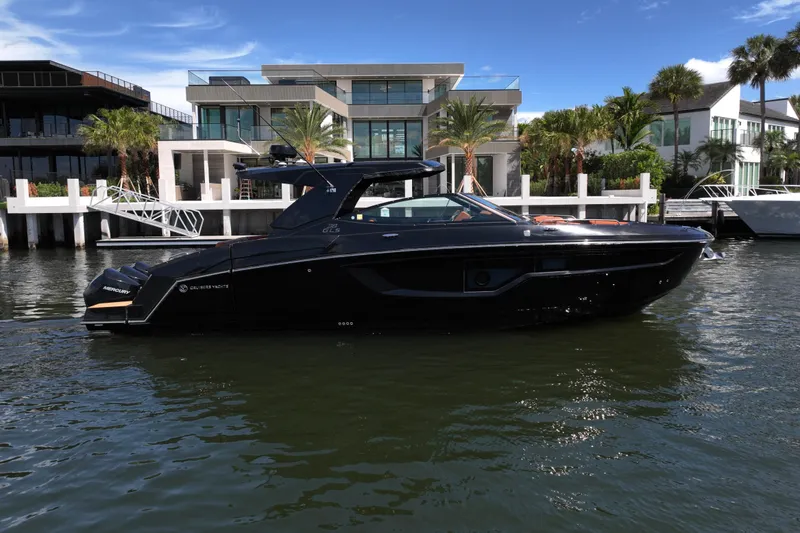 Slide: The Image of 2022 Cruisers Yachts 38 GLS OB in water, modern waterfront homes in background. - 3