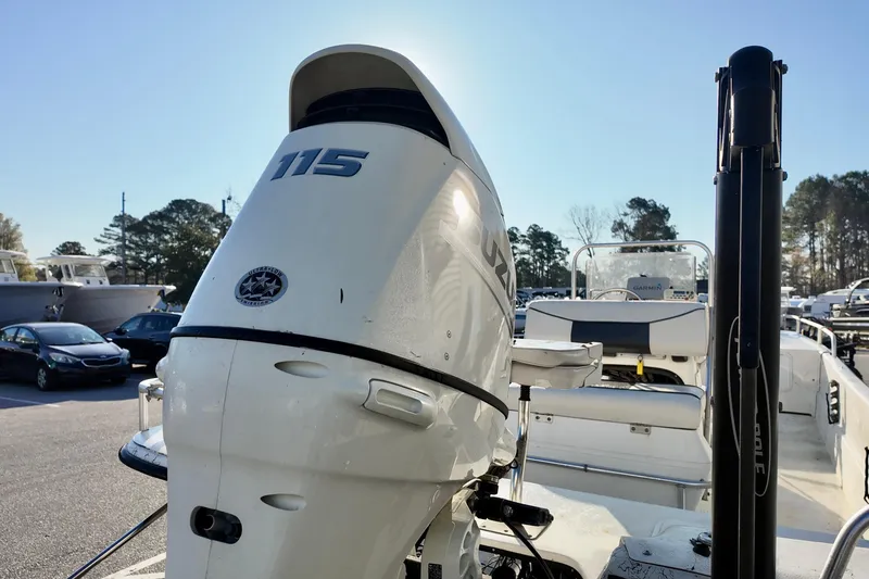Slide: The Image of 2009 Carolina Skiff 18 DLX with Suzuki 115 outboard motor in a parking lot. - 13