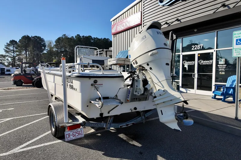 Slide: The Image of 2009 Carolina Skiff 18 DLX boat on trailer outside dealership, featuring outboard motor. - 15