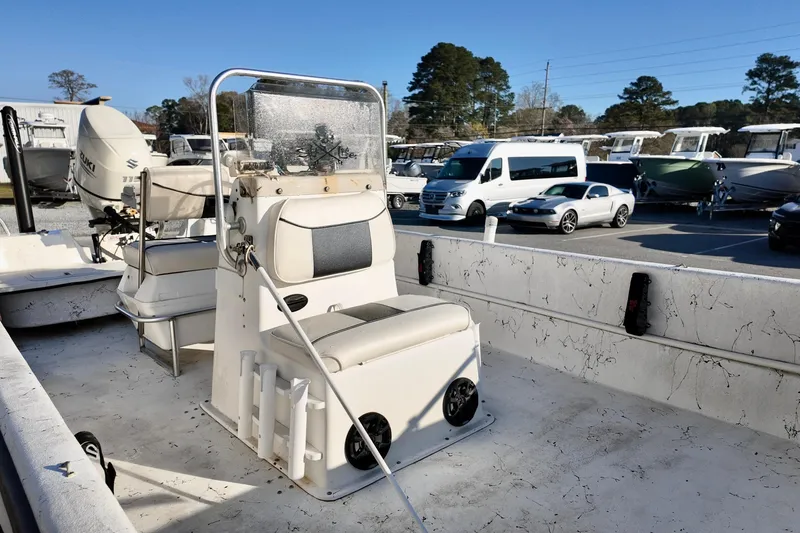 Slide: The Image of 2009 Carolina Skiff 18 DLX boat interior with seating and console, parked outdoors. - 9