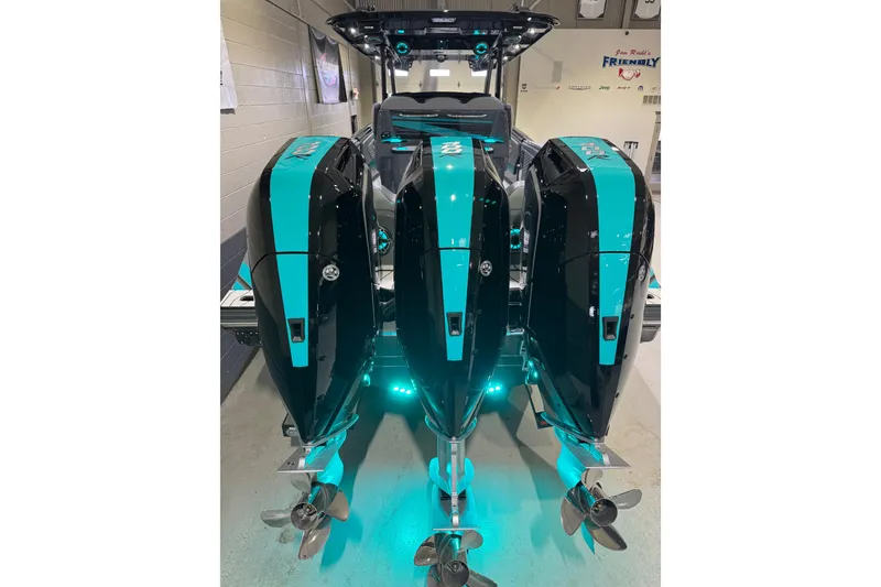 Slide: The Image of 2026 Sunsation 34 CCX boat with triple outboard engines, teal and black design. - 5