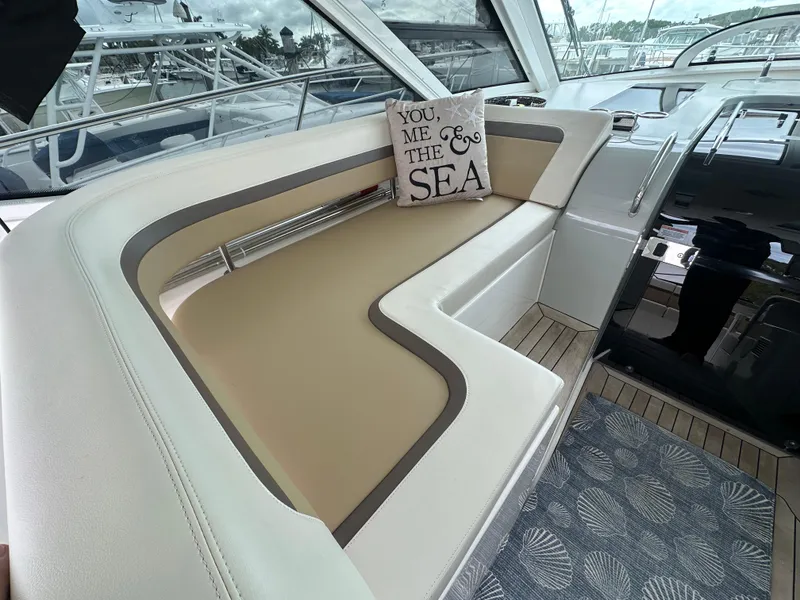 Slide: The Image of 2010 Sea Ray 470 Sundancer interior with cushioned seating and decorative pillow. - 14