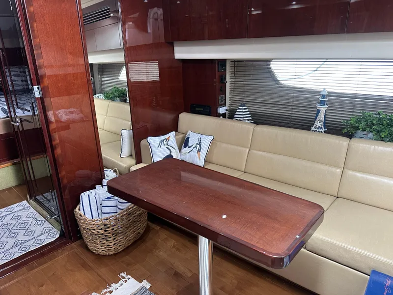 Slide: The Image of Interior of 2010 Sea Ray 470 Sundancer yacht with beige seating and wooden table. - 24