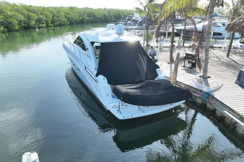 Slide: The Image of 2010 Sea Ray 470 Sundancer yacht docked by a tropical waterfront. - 4