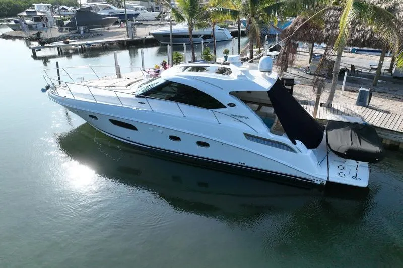 Slide: The Image of 2010 Sea Ray 470 Sundancer yacht docked in a serene marina setting. - 6