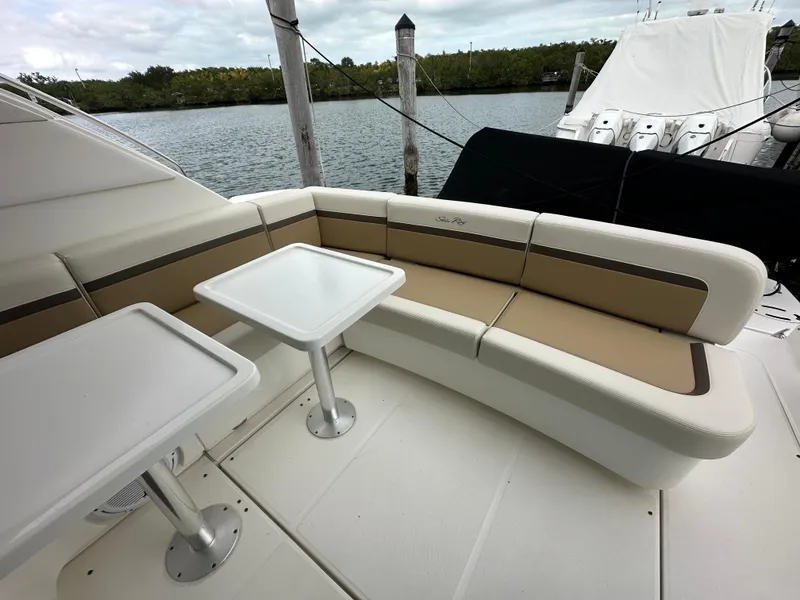 Slide: The Image of 2010 Sea Ray 470 Sundancer yacht with outdoor seating and tables by the water. - 8