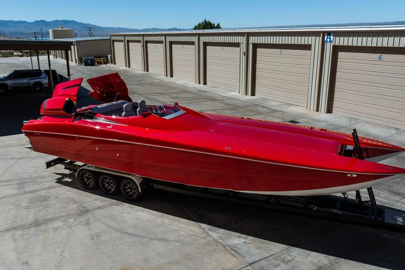Slide: The Image of Red 2008 Nor-Tech 3600 Supercat powerboat on trailer, parked near storage units. - 13
