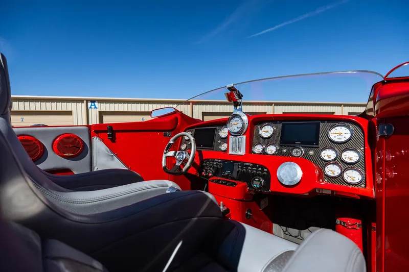 Slide: The Image of Interior of a 2008 Nor-Tech 3600 Supercat boat with red dashboard and gauges. - 24