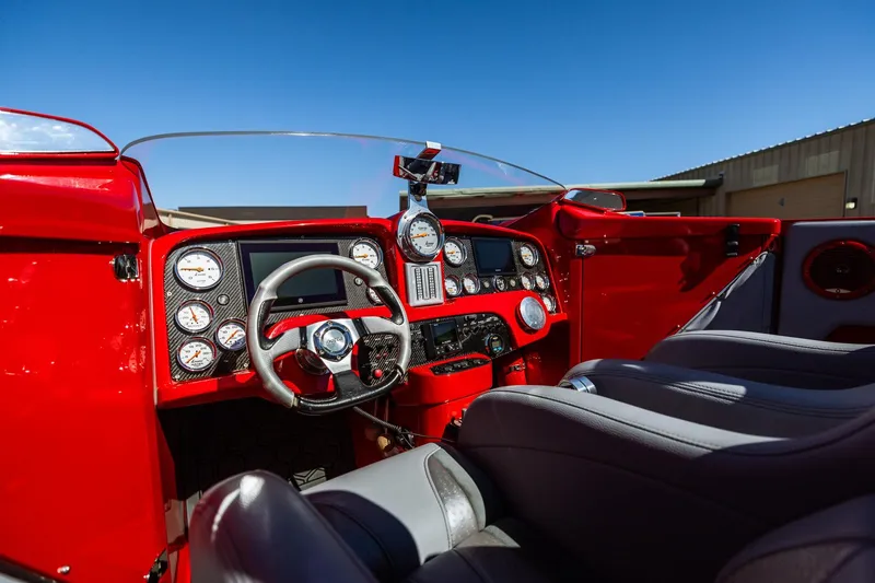 Slide: The Image of 2008 Nor-Tech 3600 Supercat cockpit with red dashboard, gauges, and steering wheel under clear blue sky. - 25