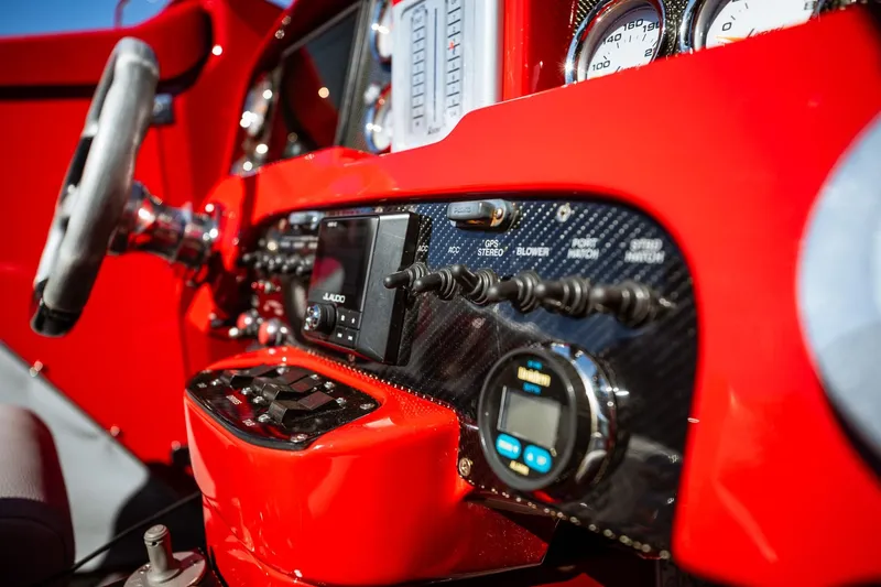 Slide: The Image of Dashboard of a 2008 Nor-Tech 3600 Supercat with red accents and control switches. - 35