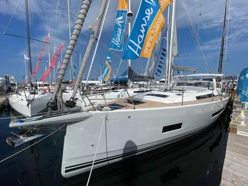 The Image of 2023 Hanse 460 yacht docked at marina, showcasing sleek design and vibrant flags. - 1