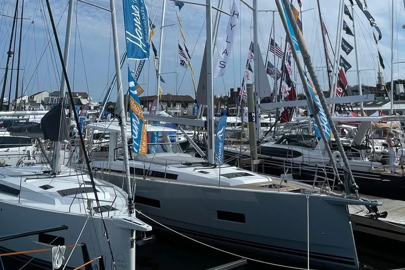 Slide: The Image of 2023 Hanse 460 yacht displayed at a marina, surrounded by flags and other boats. - 13