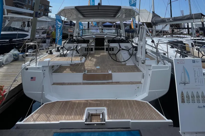 Slide: The Image of 2023 Hanse 460 yacht with spacious deck and dual steering wheels at a marina. - 14