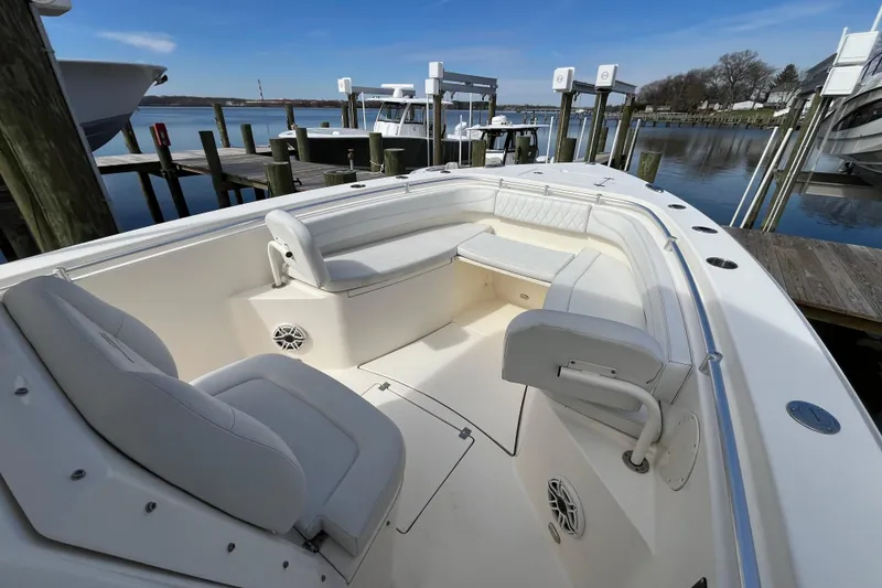 Slide: The Image of 2020 Cobia 301 Center Console boat interior at dock, featuring spacious seating and sleek design. - 15