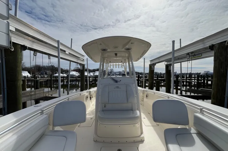 Slide: The Image of 2020 Cobia 301 Center Console boat docked at a marina under cloudy skies. - 16