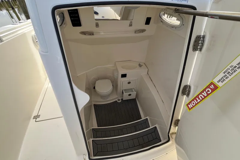 Slide: The Image of 2020 Cobia 301 Center Console boat interior with compact bathroom and toilet. - 20