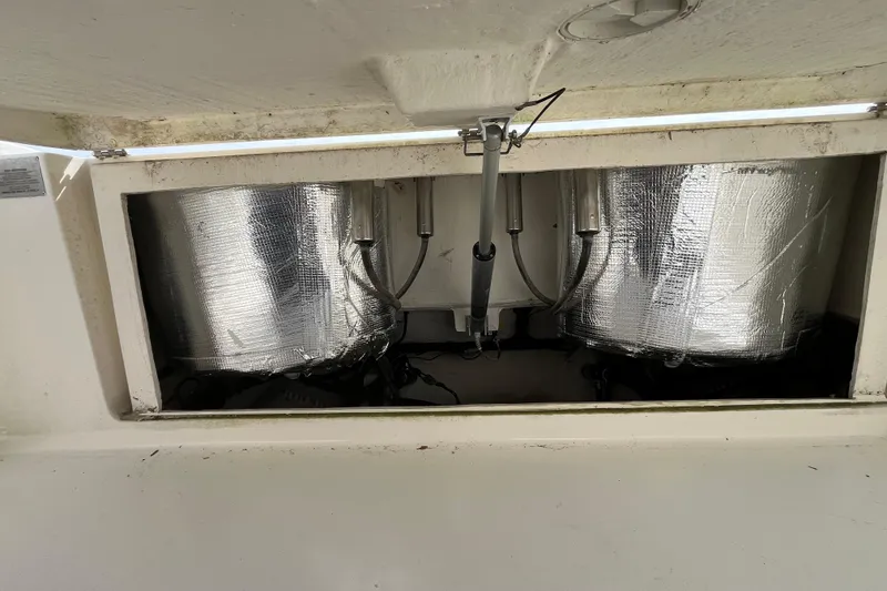 Slide: The Image of 2020 Cobia 301 Center Console boat compartment with insulated tanks and hydraulic components. - 23