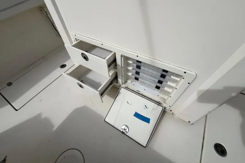 Slide: The Image of 2020 Cobia 301 Center Console storage compartments with open drawers and tackle box. - 4